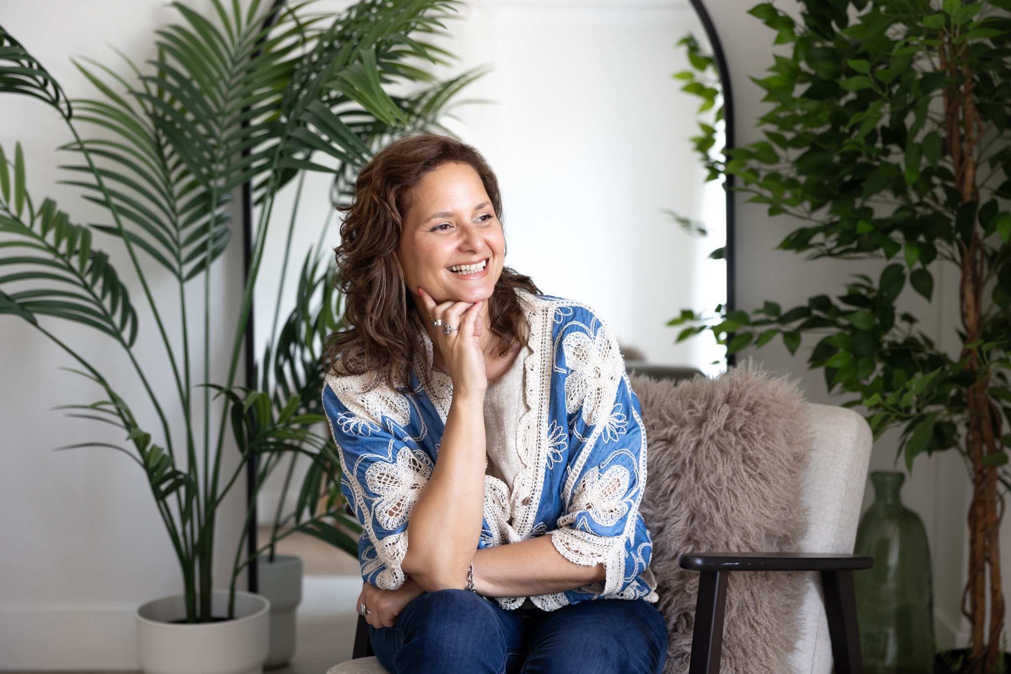 Haidee smiling, seated among green plants